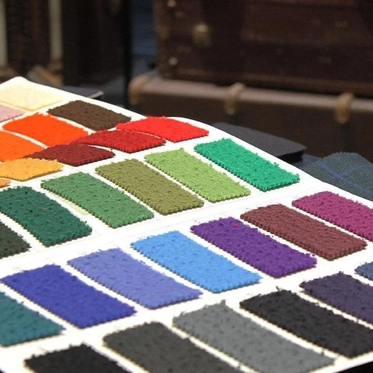 Nuancier de coloris de tissus présenté sur la table de coupe de l’atelier
